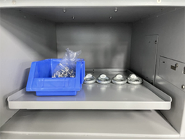Parts bin and calibration weights positioned across an Akris weighing plate