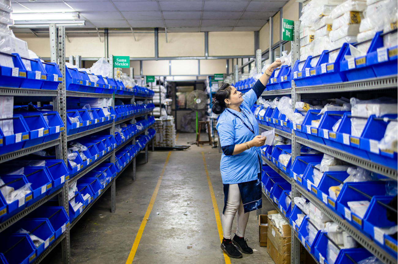 An employee collecting supplies from labelled blue storage bins