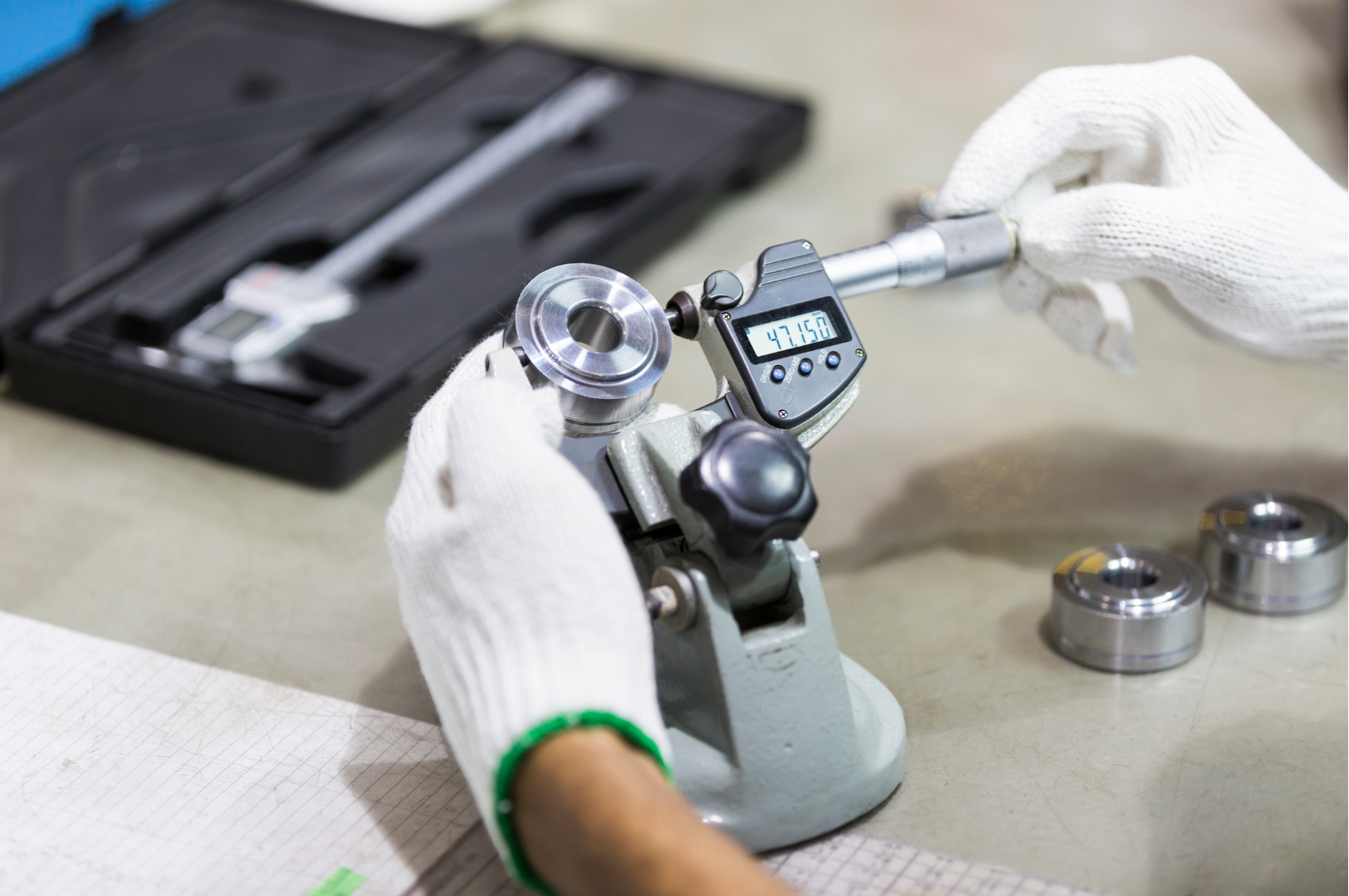 A precision component being measured with a digital micrometer